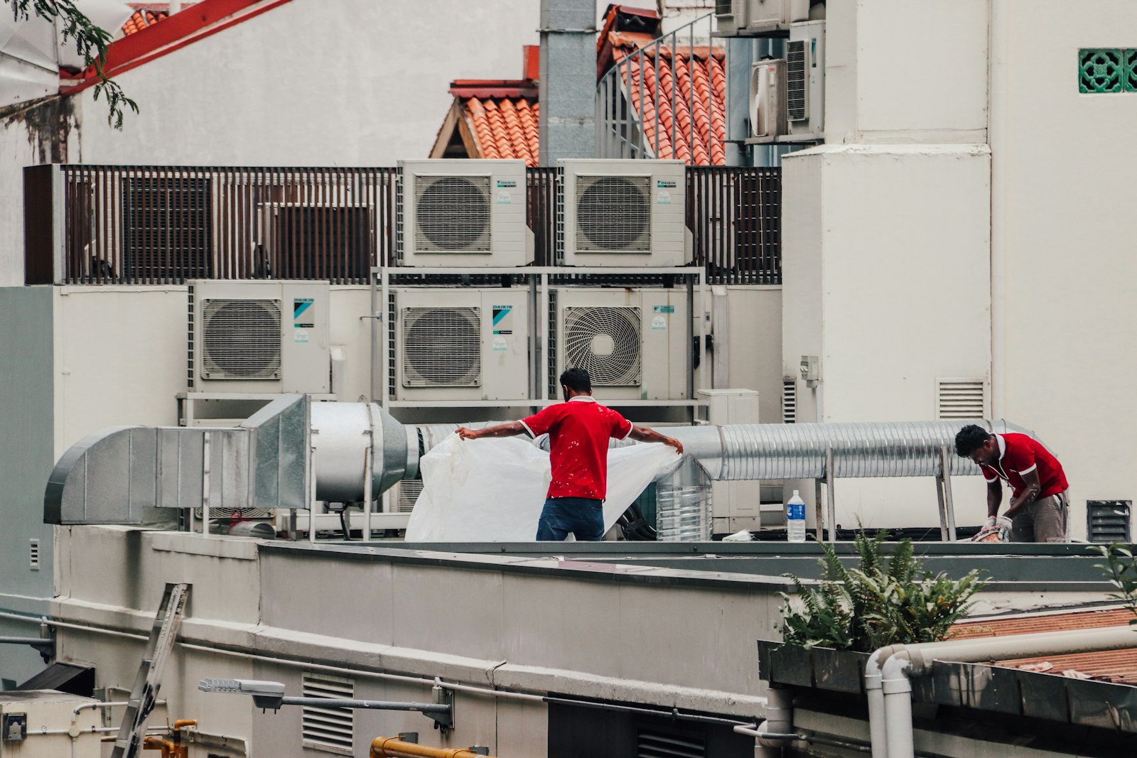 Crew servicing rooftop commercial air conditioning units